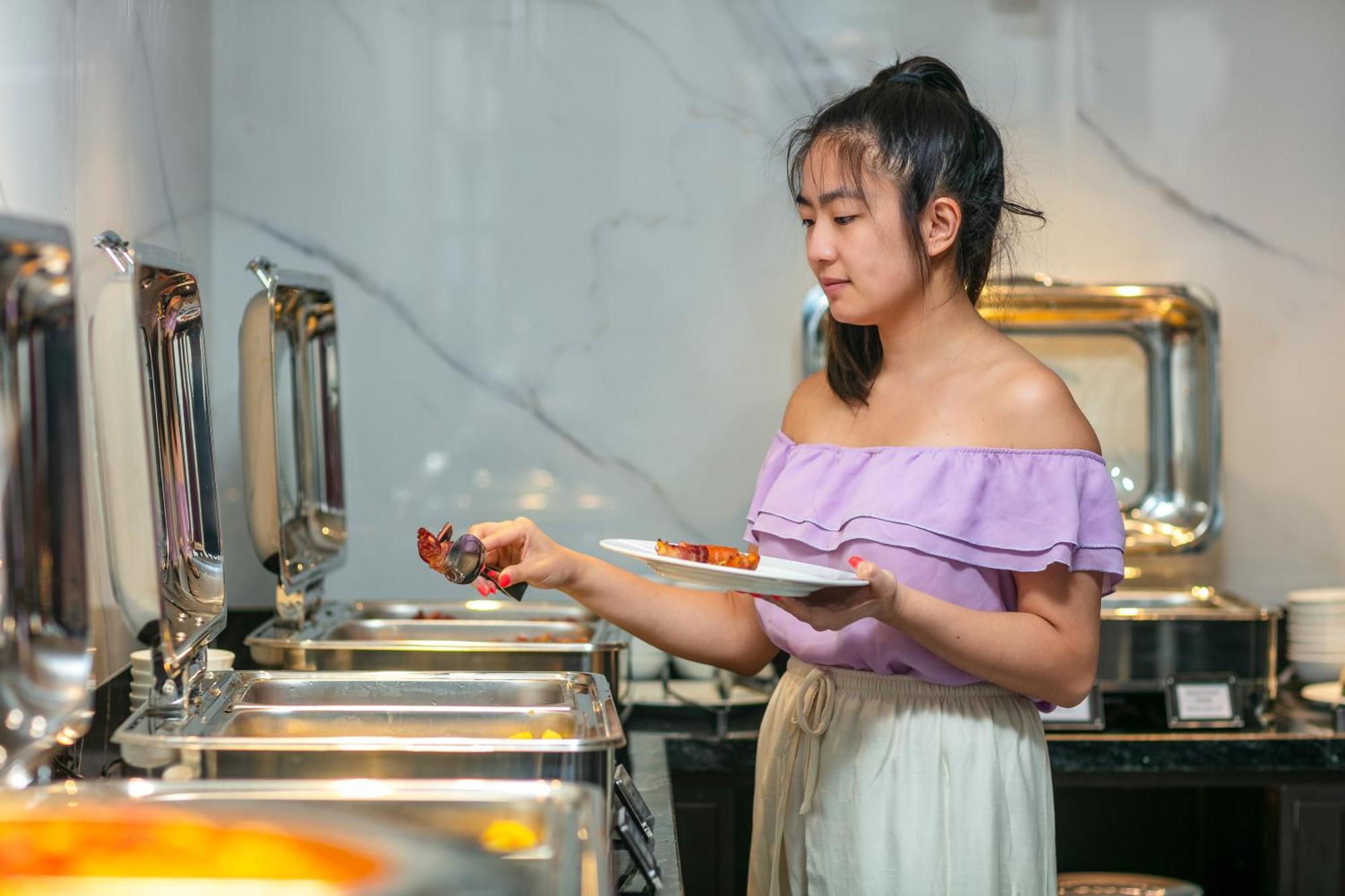 May De Ville Lakeside Hotel Hanói Exterior foto A woman serving herself at a buffet